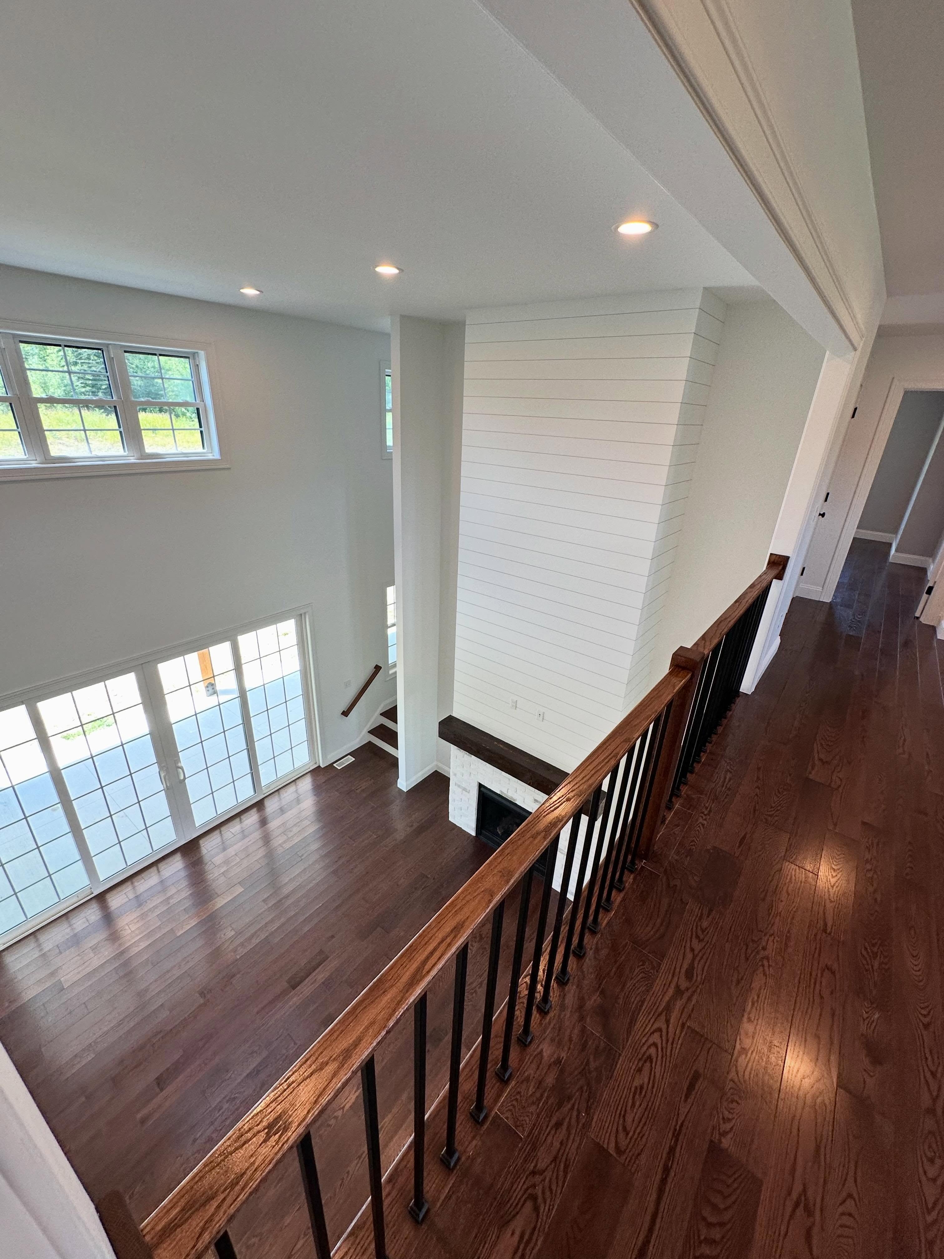 Loft overlook with wood rail and iron balusters