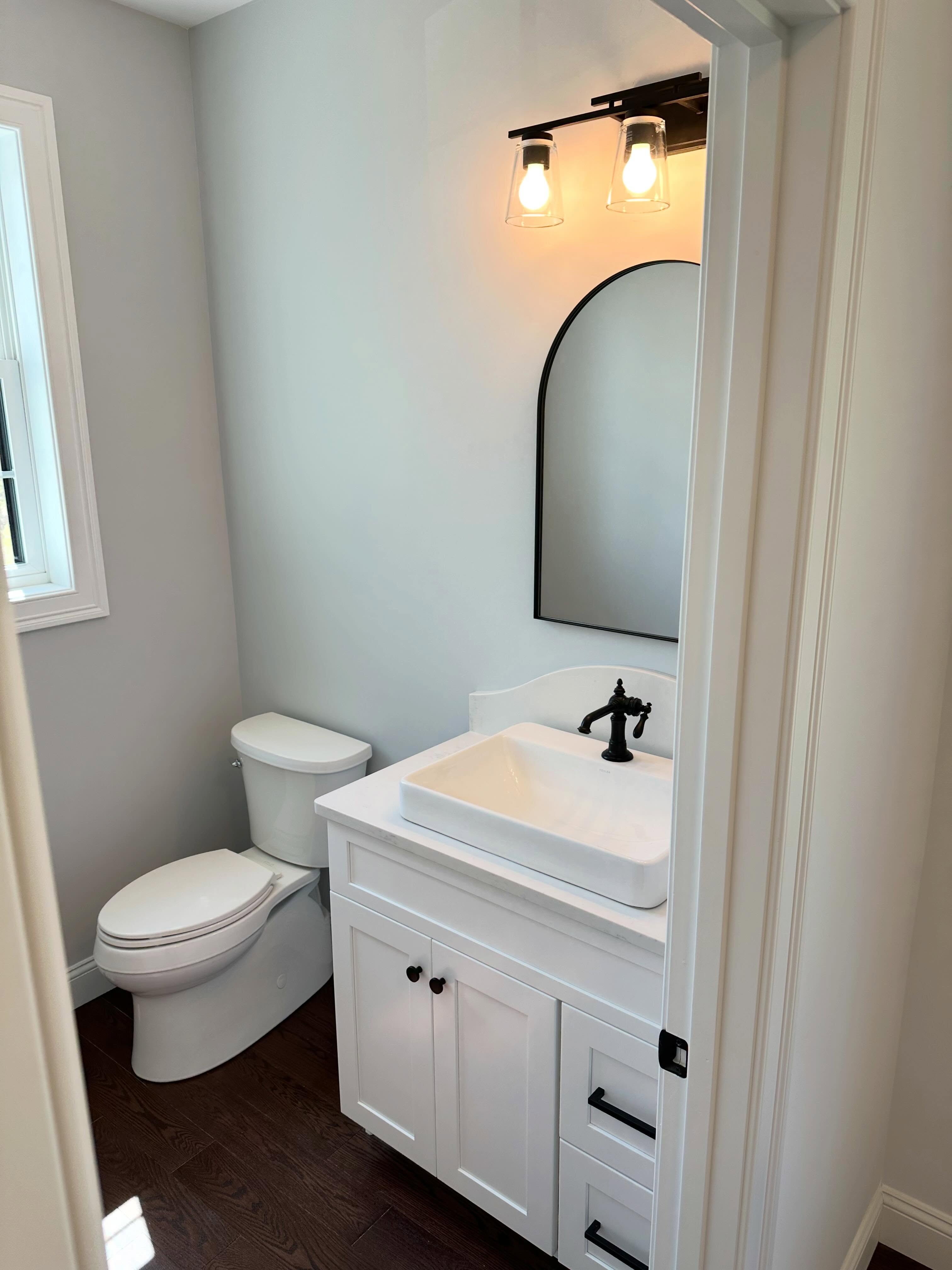 Powder room with vessel sink and arch mirror