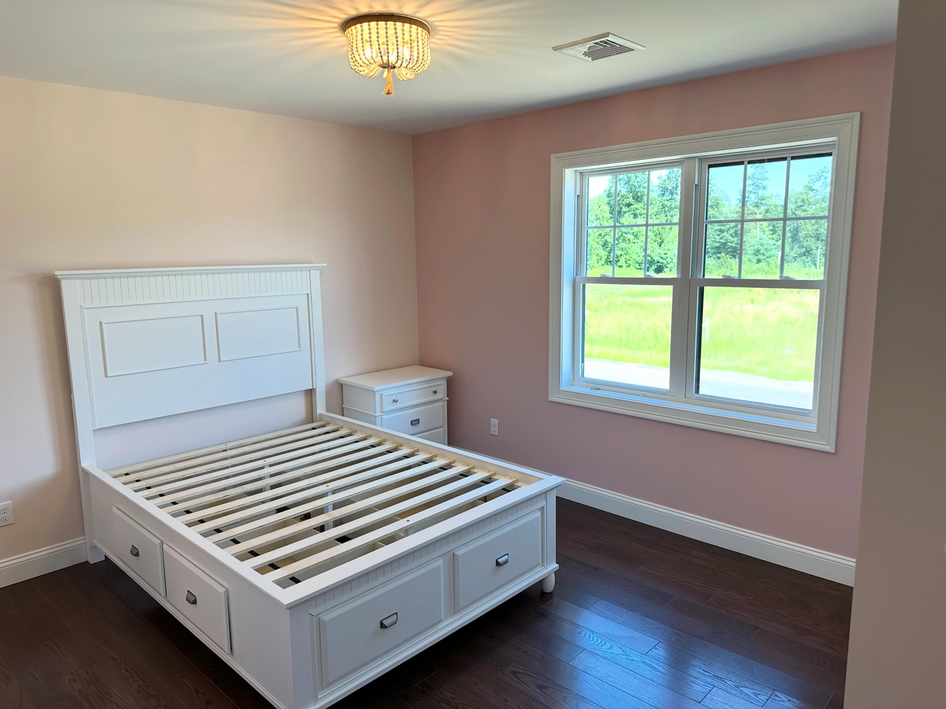 Finished bedroom with large window over open field