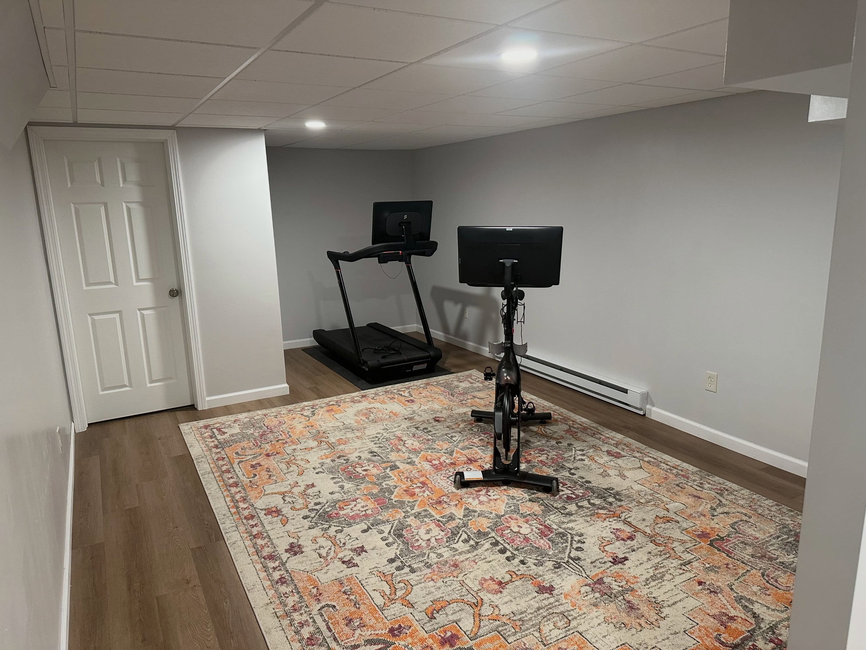 Basement home gym with treadmill and bike