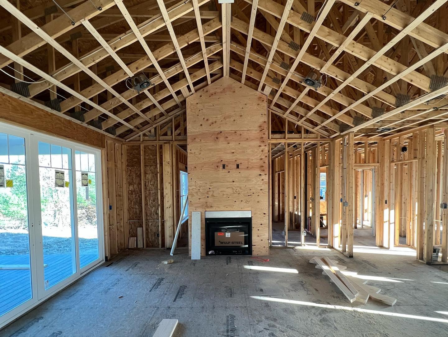 Raw framed great room with trusses and fireplace chase under construction