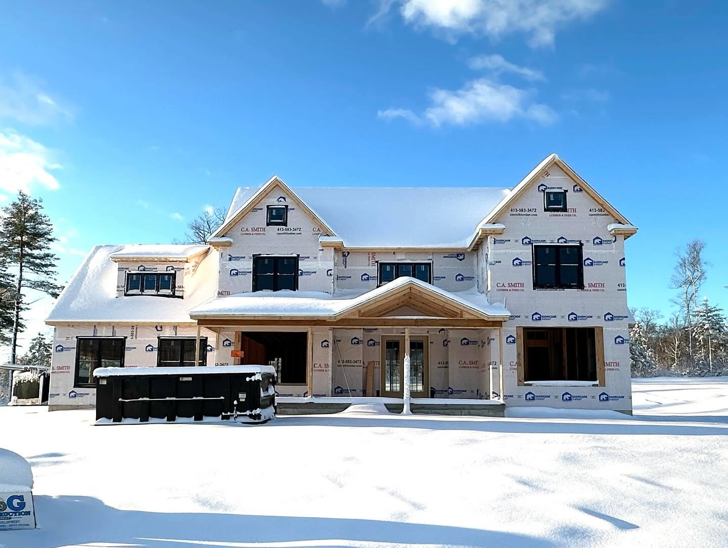 Farmhouse framed and wrapped, surrounded by snow